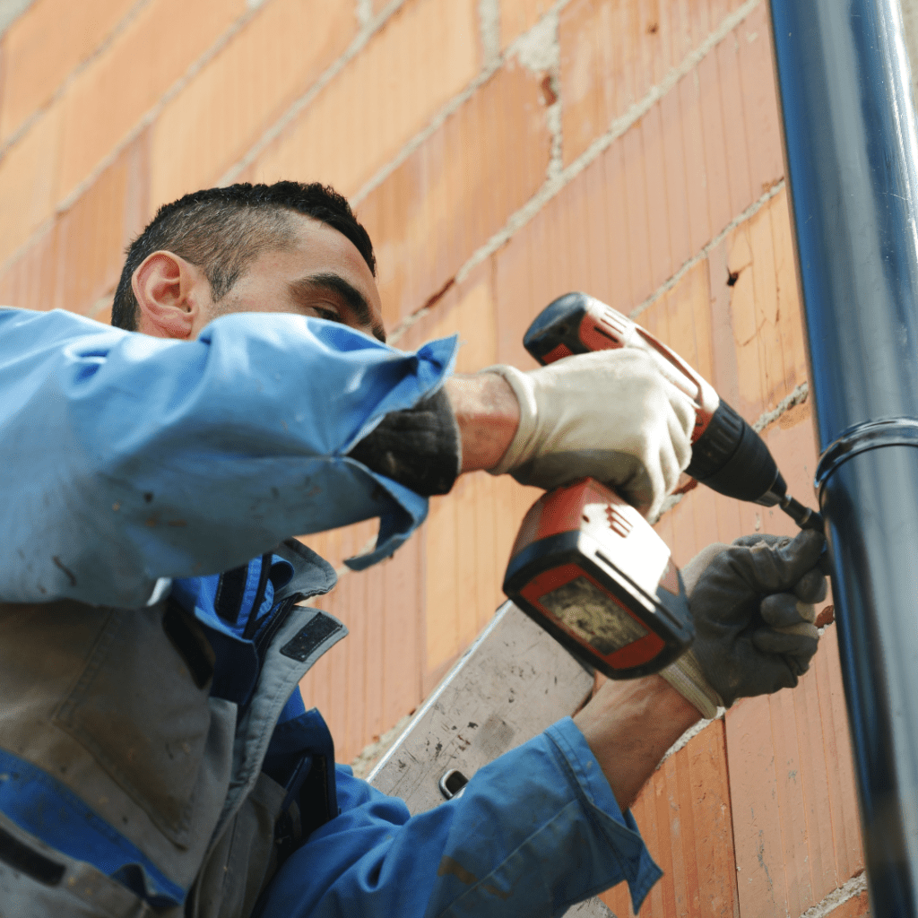 Professionnel travaillant sur un système d'évacuation des eaux de pluie